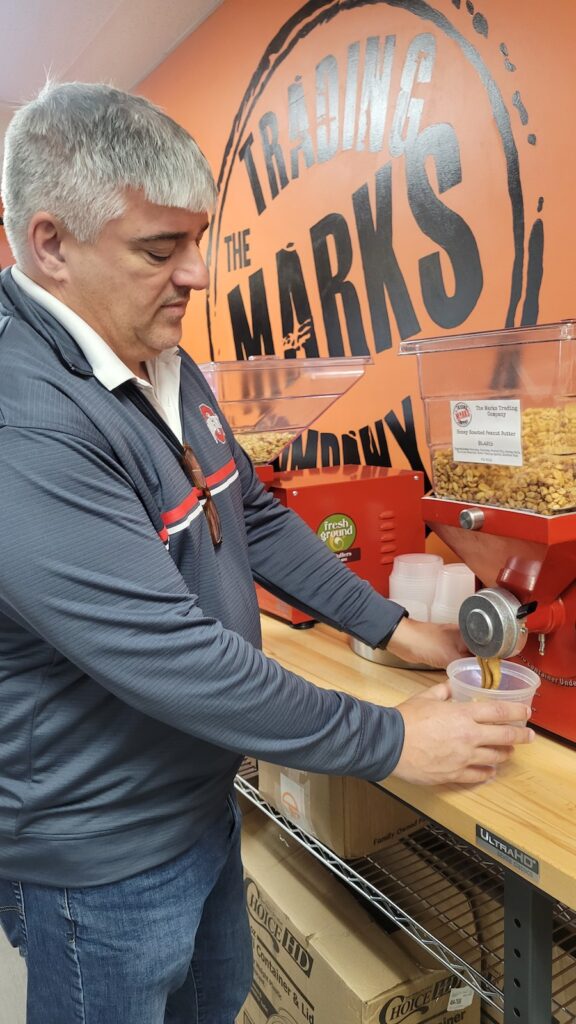 Co-owner Jay Marks grinds fresh peanut butter at the Marks Trading Company in Adrian.